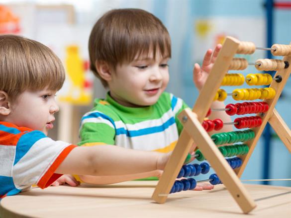 Children gathered around a Logic Roots math game